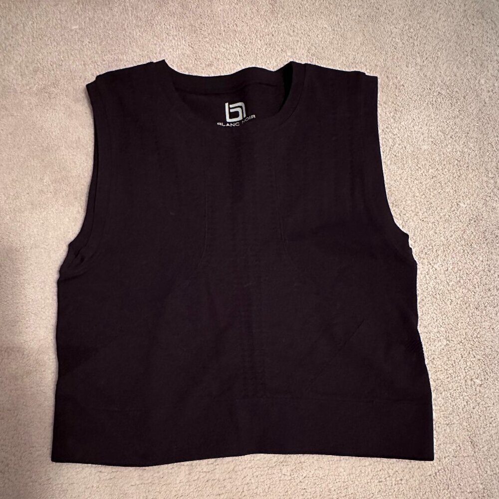 Blanc Noir perforated solid mid-drift top.
